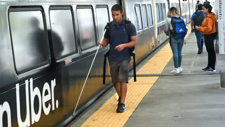 A blind man catches a train in Denver, Colorado
