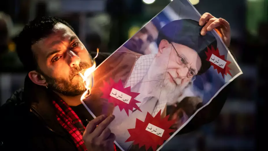 Un manifestante quema una foto del ayatolá Ali Jamenei, en Irán