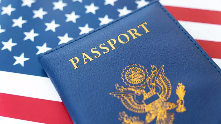 Un pasaporte estadounidense sobre una bandera americana.