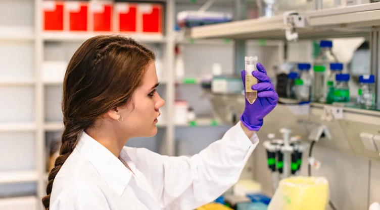 Female scientist holding flask with medicine in laboratory