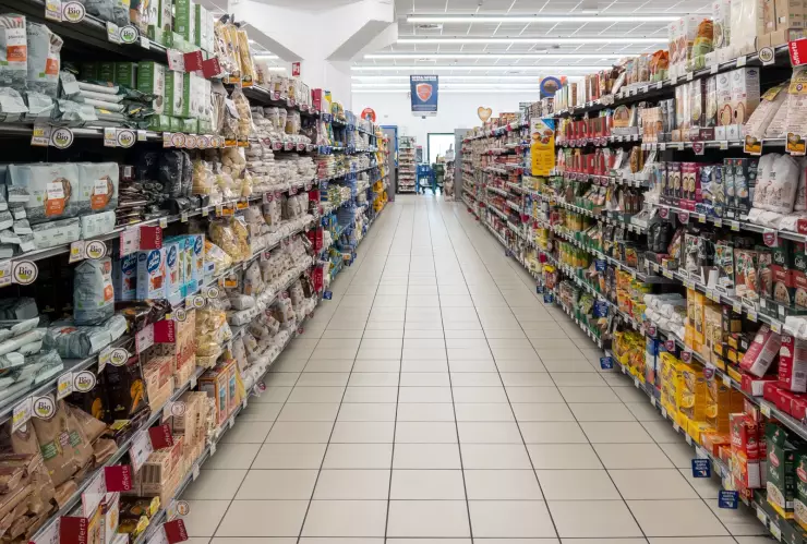 Pasaje de un supermercado en Texas con góndolas de comida y productos.