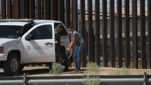 Una patrulla de la CBP revisa a un hombre en la frontera.