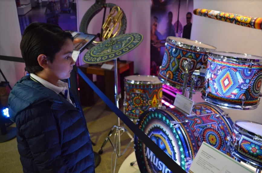 Alumno de Jules Verné School maravillado con los instrumentos que Hermes Music trajo a la Villa Juguetón