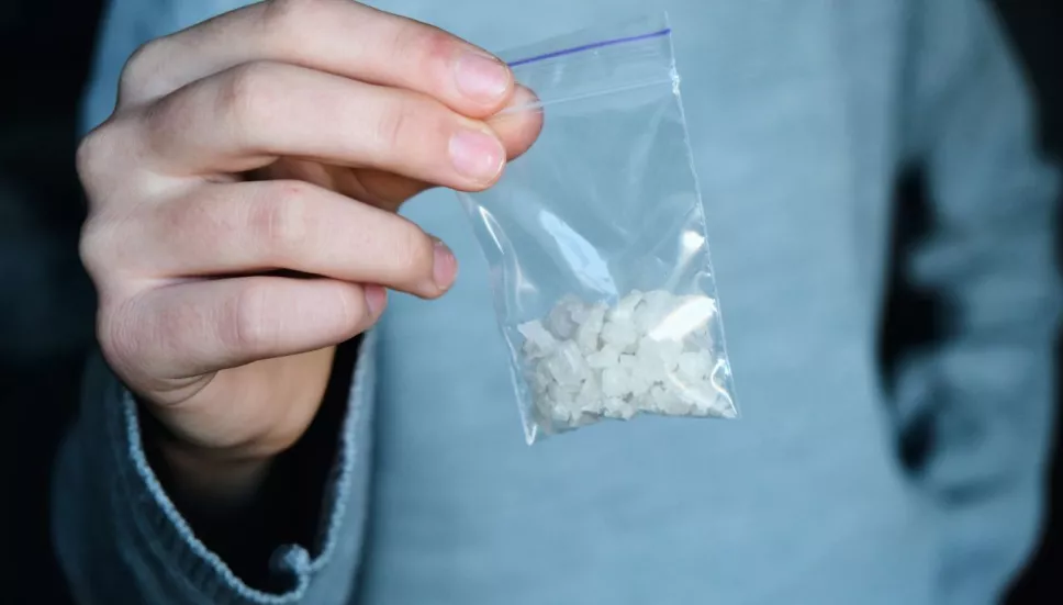 persona sosteniendo una bolsita de metanfetamina