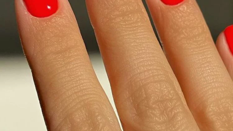 Uñas color rojo tomate para manos bronceadas en verano