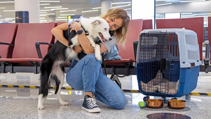 Una mujer junto a su perro en el aeropuerto
