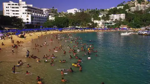 Una imagen de la playa Caleta en Acapulca con turistas de vacaciones.