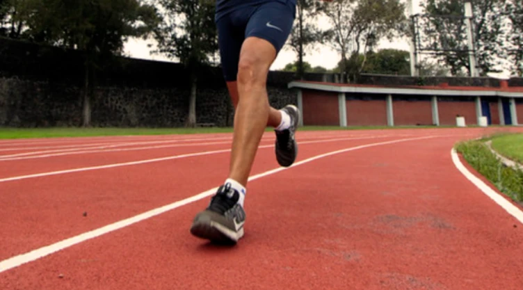 Persona corriendo sobre una pista de atletismo