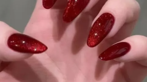 uñas en rojo ojo de gato con glitter