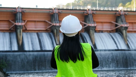 Una mujer se desempeña en el puesto de energía hidroeléctrica