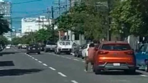 Hombre desnudo cuelga de auto en movimiento