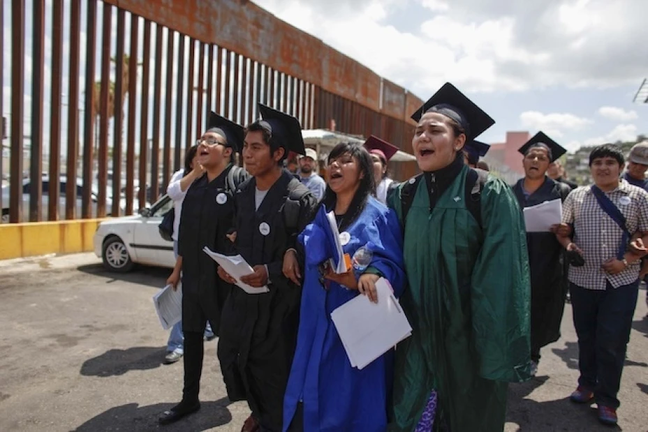 “Dreamers” marchan con brazos cruzados vistiendo sus togas y birretes de graduación para mostrar su deseo de culminar sus estudios en Estados Unidos