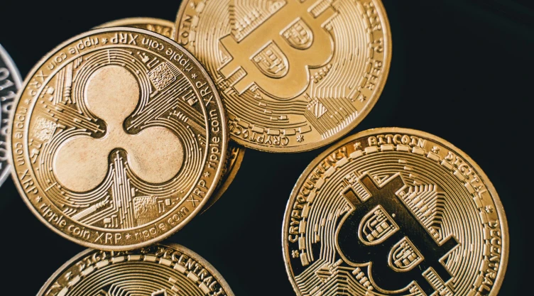 5 claves que debes tener en cuenta al invertir en criptomonedas para no perder dinero. En la imagen se observa dos mondas de oro que hacen referencia a las poderosas criptomonedas de Bitcoin y XRP de Ripple.