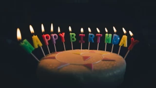 Pastel con velas de Feliz Cumpleaños.