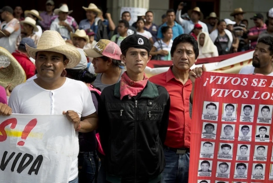 Manifestantes sostienen una pancarta con las imágenes de los desaparecidos durante una protesta por la desaparición de los 43 estudiantes de la escuela de maestros rurales Isidro Burogs
