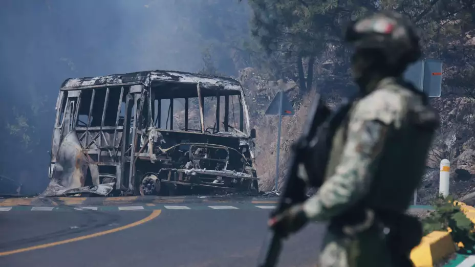 Un camión incinerado bloquea una carretera en Jalisco.