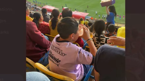 Niño tomando cerveza en estadio