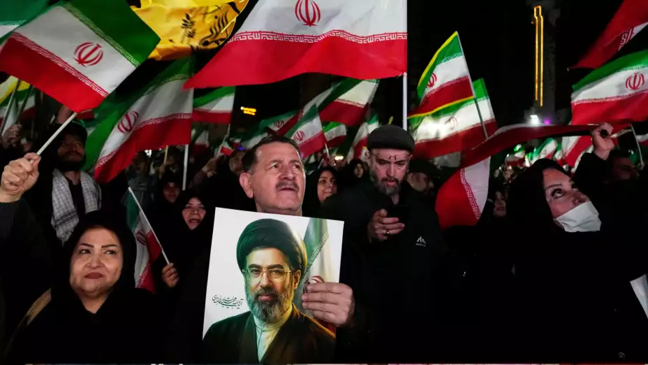 Manifestantes iraníes ondean banderas en apoyo del ayatolá Mojtaba Jamenei.