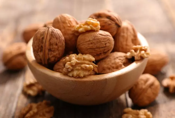 bowl con nueces, algunas abiertas y otras aún con cáscara