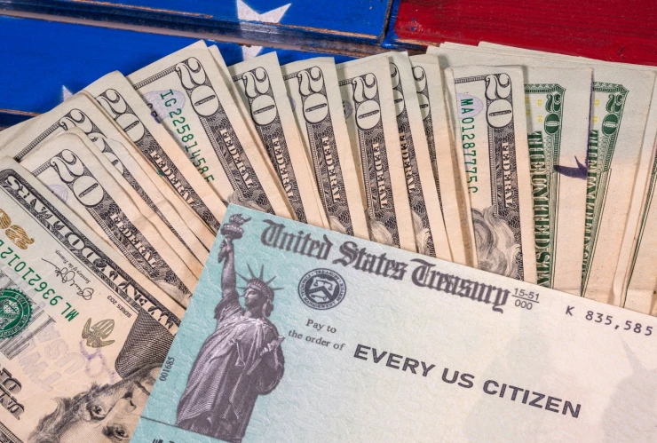 Cheque de estímulo junto a dólares estadounidenses