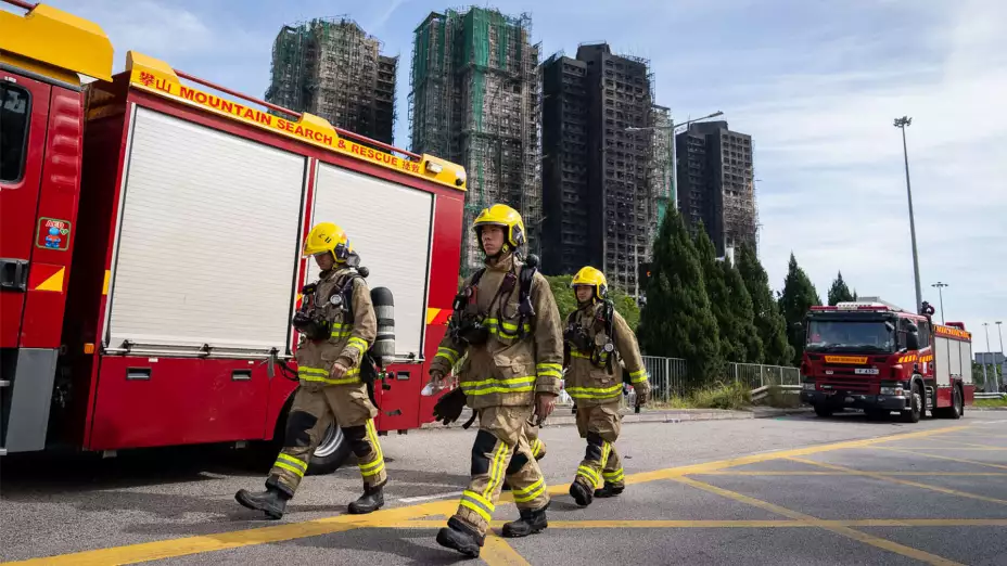 Bomberos frente a rascacielos que se incendiaron en Hong Kong.