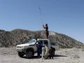 Un miembro del Talibán intenta obtener una señal de comunicación en la parte superior de un vehículo en la zona afectada por el terremoto de la aldea de Wor Kali, Afganistán.