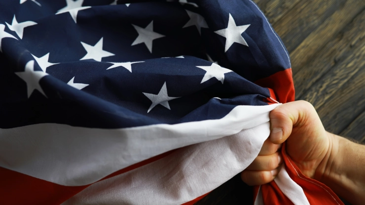 Una persona agarra una bandera de Estados Unidos.