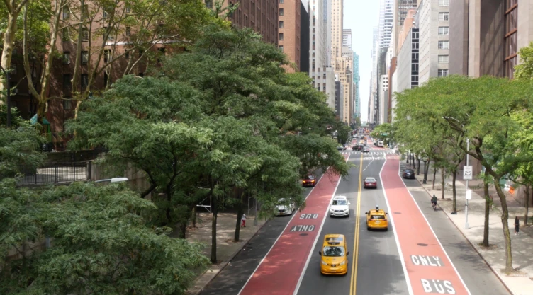 Autos avanzan por calle de Manhattan, Nueva York