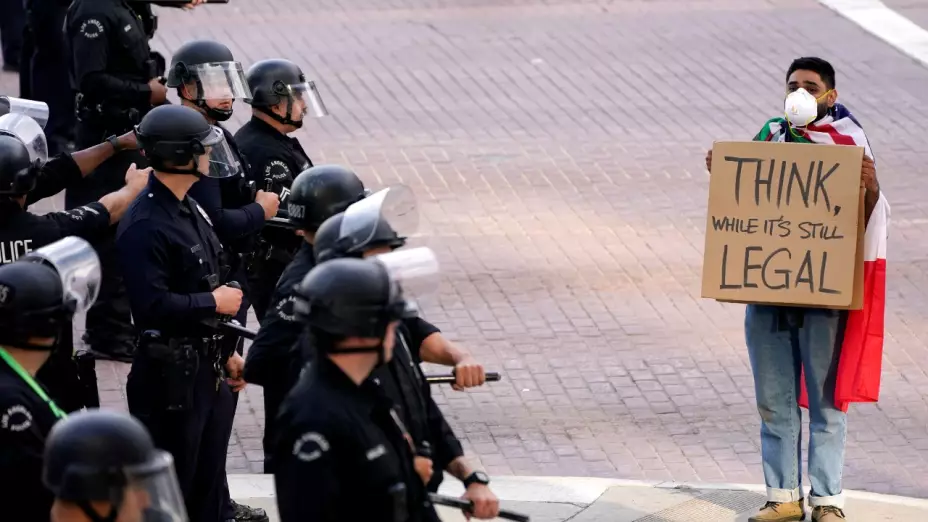 protestas_no_king_agentes_repliegan_gas_lacrimogeno_manifestante_letrero_bandera_mexico_policias_cascos