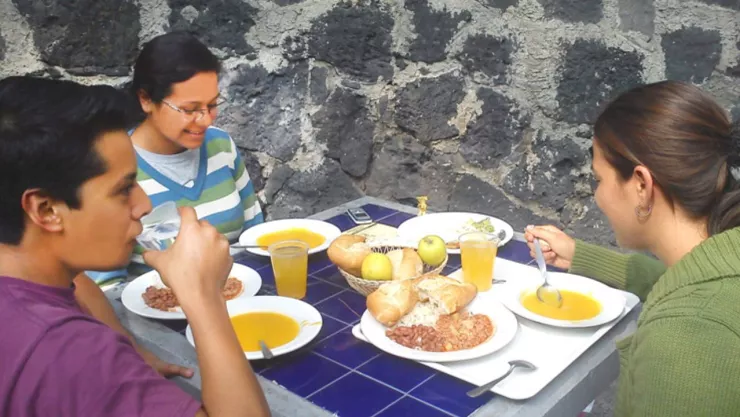 Tres estudiantes de la UNAM comiendo en las instalaciones de CU.
