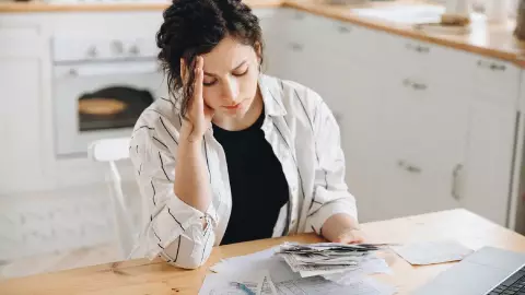 una mujer observa preocupada los gastos que tiene que afrontar