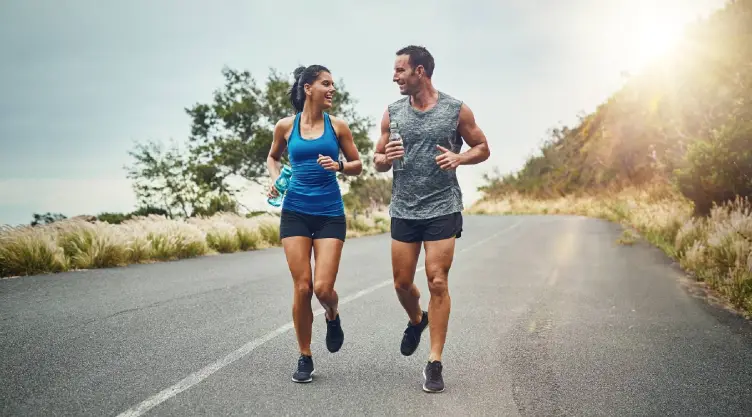 una pareja corre feliz sobre una colina