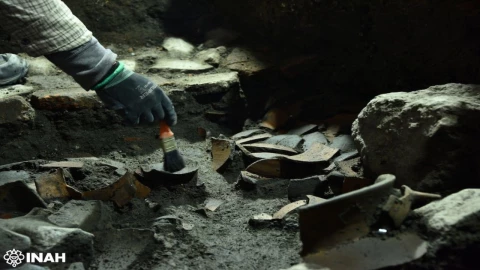 Especialista del INAH recuperando piezas cerámicas durante un salvamento arqueológico en La Lagunilla