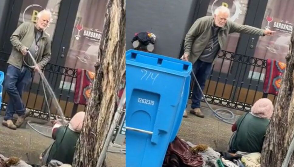 Empresario lanza agua con una manguera a una mujer en situación de calle.