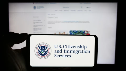 Un celular con la página oficial del USCIS
