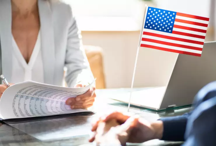 Una funcionaria firma un documento de solicitud de visa