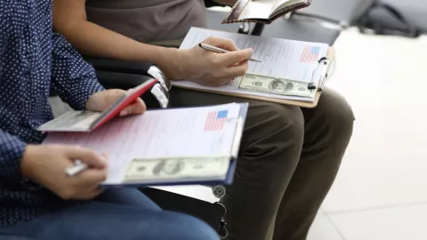 Dos personas revisan sus formularios para solicitar visa a Estados Unidos.