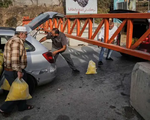 Palestinos frente a una barrera militar que cierra el paso en Hebrón, Cisjordania.