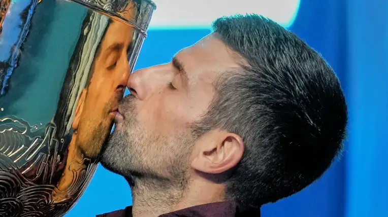 Novak Djokovic besa el trofeo de campeón del Abierto de China.