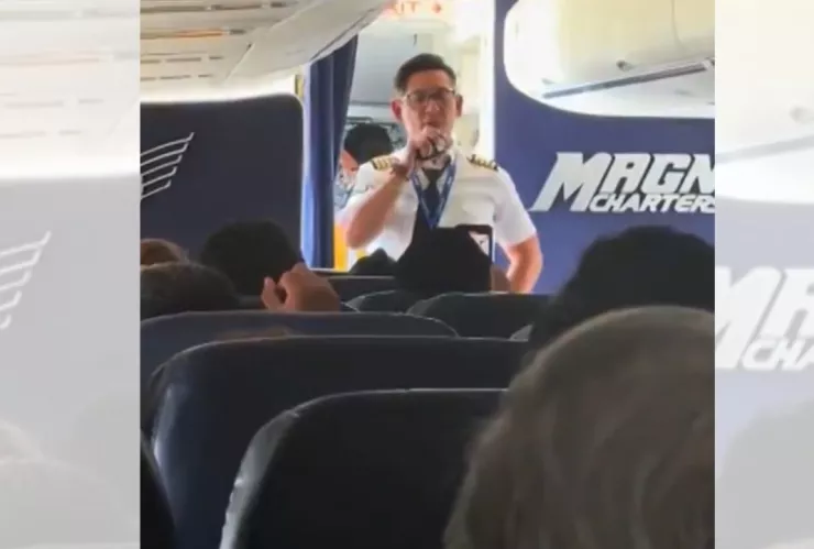 Piloto de la aerolínea Magnicharters habla con pasajeros dentro de la cabina de un avión en el AICM, durante un incidente que mantuvo el vuelo en tierra.