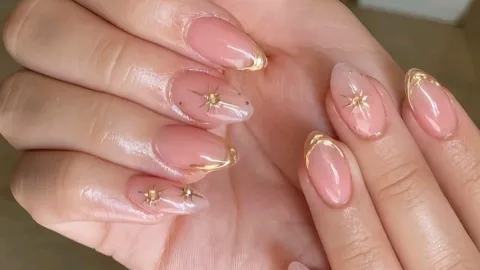 Detalles dorados minimalistas sobre uñas nude