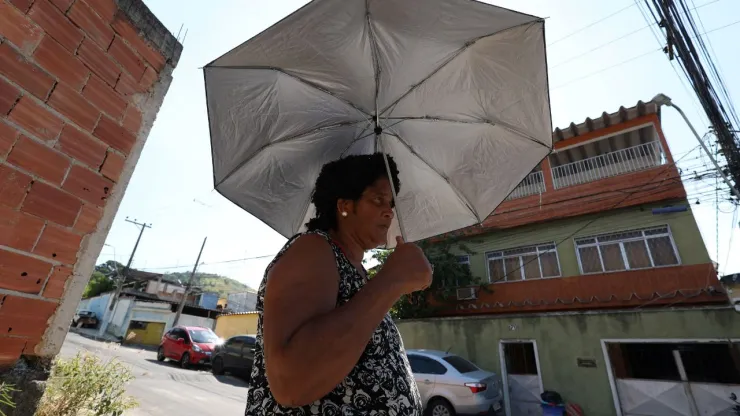 Mujer se protege del sol con una sombrilla en medio de una ola de calor extrema en