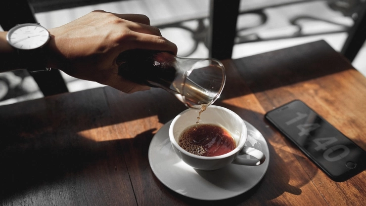 Fotografía de una taza de café humeante sobre una mesa.