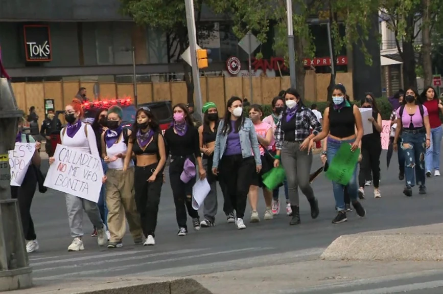 Jóvenes caminan en grupo durante la marcha del 25N