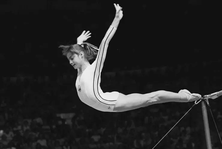 Nadia Comaneci, of Romania, dismounts from the uneven parallel bars at the Olympic Games in Montreal