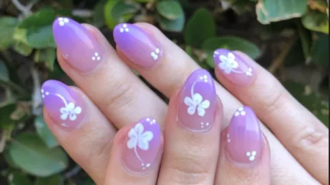 uñas moradas con flores a mano alzada