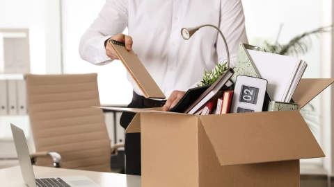 Un empleado despedido mete sus cosas en una caja.