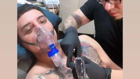 Eduin Caz en plena sesión de tatuado.