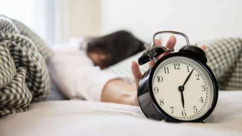 Persona en la cama por el cambio de horario
