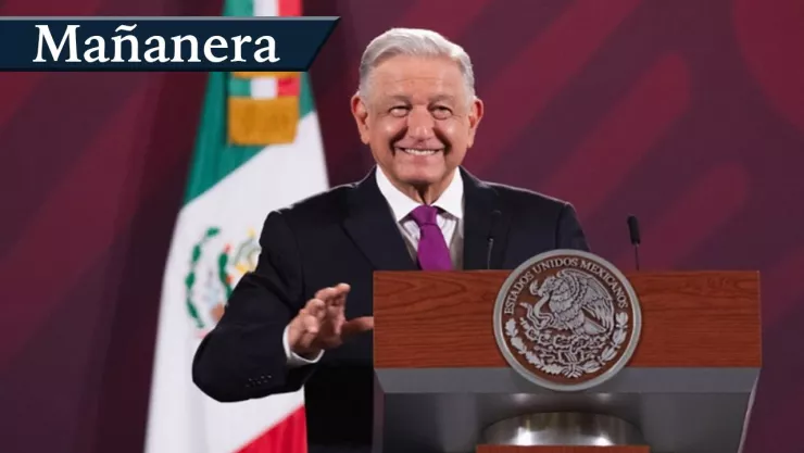Andr&eacute;s Manuelo L&oacute;pez Obrador sonriendo; detr&aacute;s de &eacute;l se encuentra la bandera de M&eacute;xico